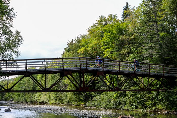 Bikers Crossing The Bridge On The Narrow Gauge Trail In Carrabassett Valley