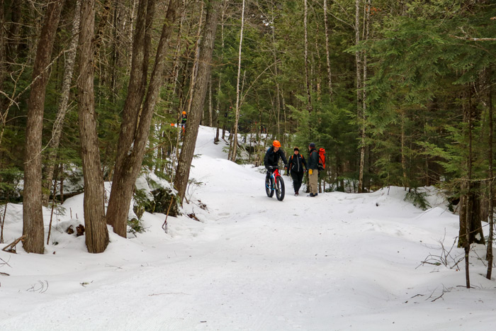 Hikers And Mountain Bikers On A Snow Covered Trail