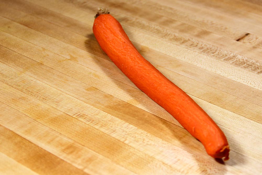 Peeled Carrot on a Wooden Cutting Board